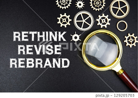 Rethink Revise Rebrand text message with magnifying glass on black background 129205703