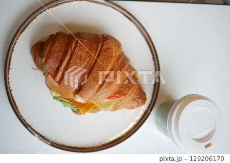 Croissant sandwich with fresh ingredients and a drink Croissant sandwich with fresh ingredients and a drink 129206170