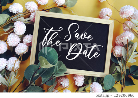 Save The Date text with flowers decoration on yellow background 129206966