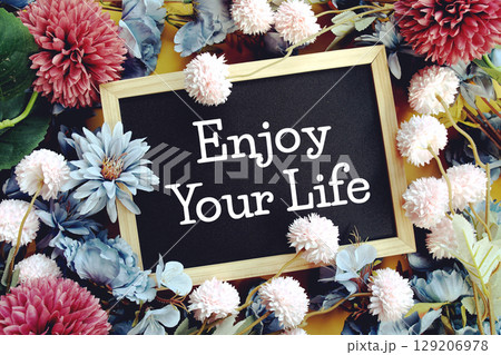 Enjoy Your Life text with flowers decoration on yellow background Enjoy Your Life text with flowers decoration on yellow background 129206978