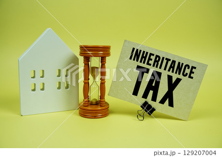 Inheritance Tax text with house model and hour glass background 129207004