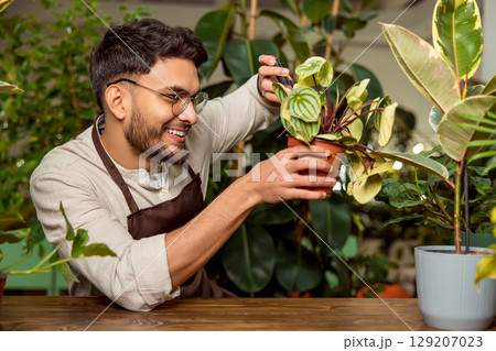 Flower shop assistant cutting the plants and looking busy 129207023