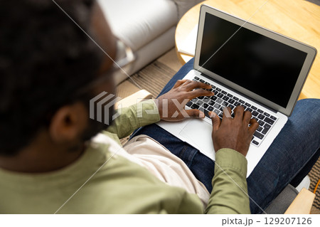Curly-haired african american young man working online from home 129207126