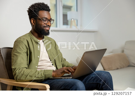 Young businessman having a video call and looking involved 129207157