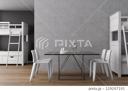 A contemporary hostel interior features wooden flooring, white bunk beds, and a sleek black dining table surrounded by chairs. The space blends comfort with practicality for travelers A contemporary hostel interior features wooden flooring, white bunk beds, and a sleek black dining table surrounded by chairs. The space blends comfort with practicality for travelers 129207191