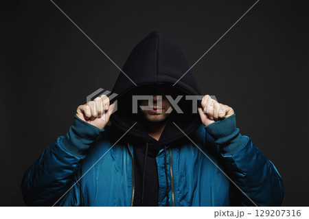 Stylish Man. Person in Black Hood and bomber jacket 129207316