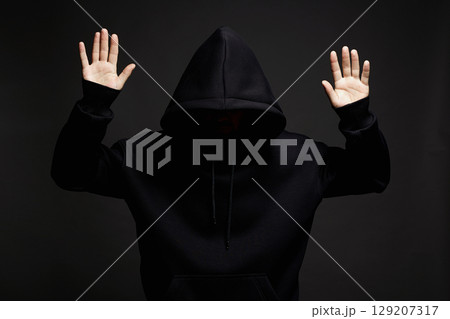 hooded man surrenders raising his hands up to be arrested hooded man surrenders raising his hands up to be arrested 129207317