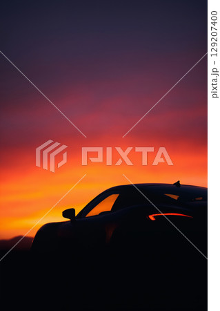 luxury sports car at night. car silhouette against a warm and vibrant sunset 129207400