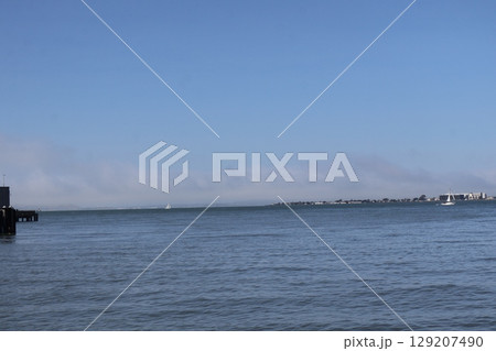 青空と青い海面の海と船と島の見える風景 129207490