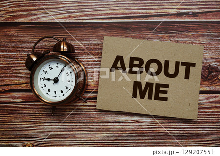 About Me text with alarm clock on wooden background About Me text with alarm clock on wooden background 129207551