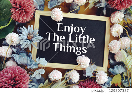 Enjoy The Little Things text with flowers decoration on yellow background 129207587