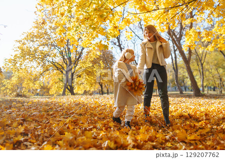 Young Mother and daughter walking in the park and enjoying the beautiful autumn nature. Walk, family 129207762
