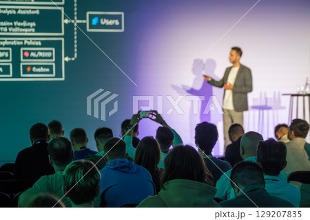 Speaker delivering presentation to engaged audience in conference setting Speaker delivering presentation to engaged audience in conference setting 129207835