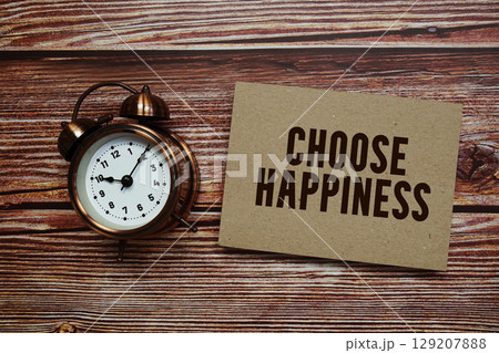 Choose Happiness text with alarm clock on wooden background Choose Happiness text with alarm clock on wooden background 129207888