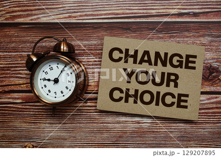 Change Your Choice text with alarm clock on wooden background 129207895