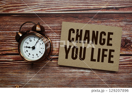 Change Your Life text with alarm clock on wooden background Change Your Life text with alarm clock on wooden background 129207896