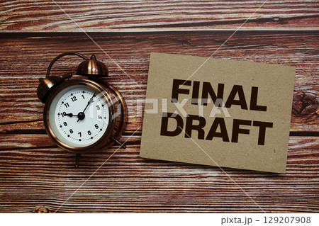 Final Draft text with alarm clock on wooden background 129207908