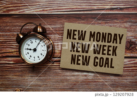 New Monday New Week New Goals text with alarm clock on wooden background New Monday New Week New Goals text with alarm clock on wooden background 129207928
