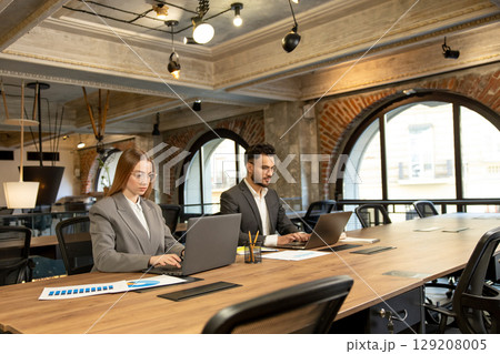 Colleagues working in the office and looking busy and involved 129208005
