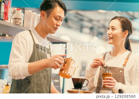 仲良くカフェで働く男女の店員 129208560