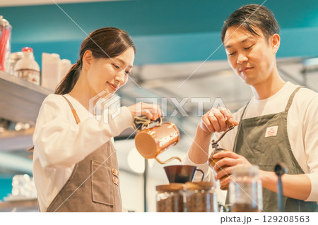 ドリップケトルでコーヒーを淹れる店員とグランドする店員 ドリップケトルでコーヒーを淹れる店員とグランドする店員 129208563
