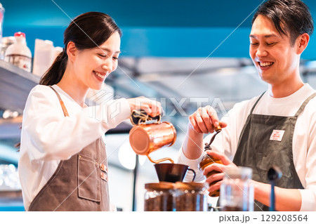 ドリップケトルでコーヒーを淹れる店員とグランドする店員 ドリップケトルでコーヒーを淹れる店員とグランドする店員 129208564