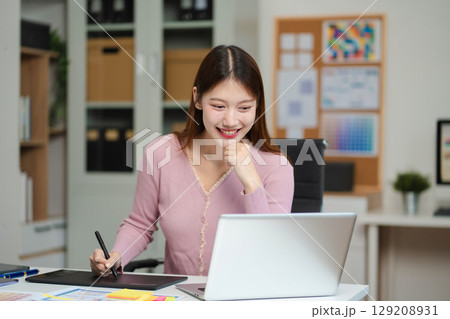 Female coder or developer working using a computer display and smartphone in problem solving at workplace. 129208931