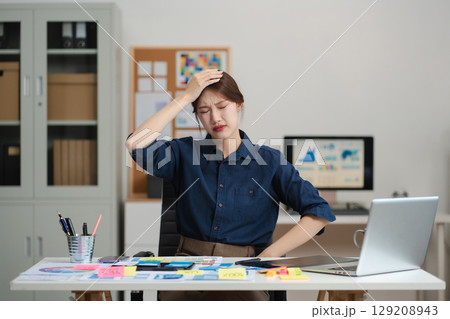 Tired asian businesswoman with headache at office, feeling sick at work. 129208943