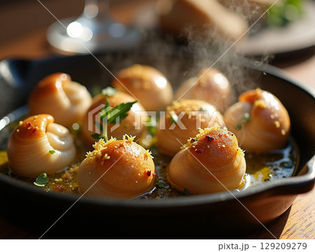 Close-up of Steaming Escargots-style Dish with Toasted Breadcrumbs 129209279