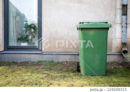 Green Garbage Bin Outside Residential Building 129209315
