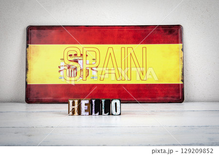 Hello Message with Wooden Letters in Front of Spanish Flag 129209852
