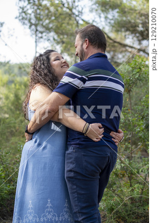 A man and woman hug in a forest 129210070