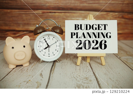 Budget Planning 2026 text message with alarm clock and piggy saving on wooden background Budget Planning 2026 text message with alarm clock and piggy saving on wooden background 129210224