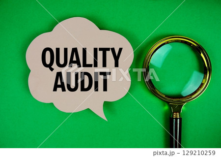 Quality Audit text with speech bubble and magnifying glass on green background 129210259