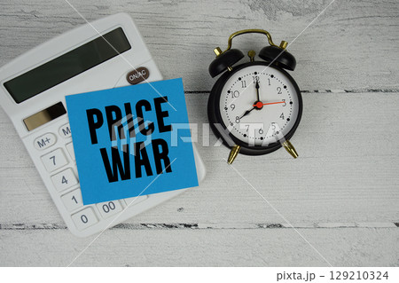 Price War text with calculator and alarm clock on wooden background Price War text with calculator and alarm clock on wooden background 129210324
