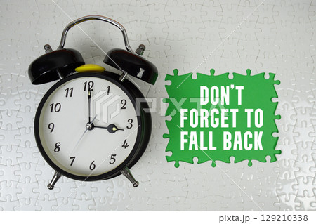 Don't Forget to Fall Back text with alarm clock on green backgroun 129210338