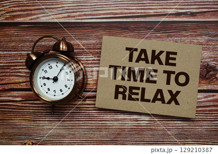 Time To Relax text with alarm clock on wooden background Time To Relax text with alarm clock on wooden background 129210387