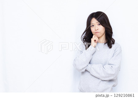 真剣に悩んでいる女性 129210861