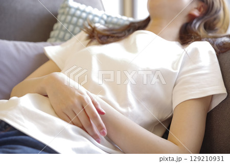 ソファでゆったりと横になる若い女性 129210931
