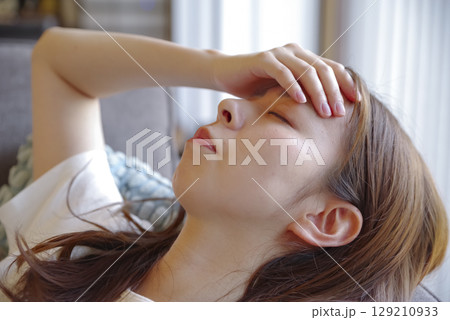 頭痛でつらそうな若い女性の表情 129210933