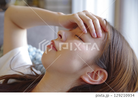 頭痛でつらそうな若い女性の表情 129210934