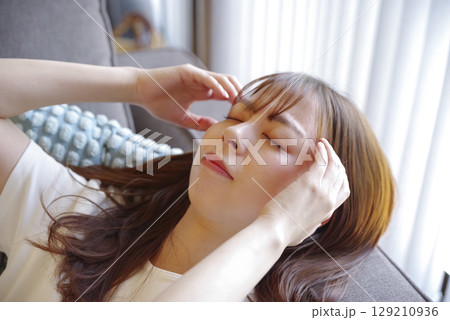 頭痛でつらそうな若い女性の表情 129210936