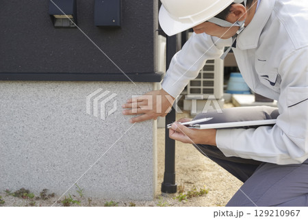 住宅の基礎部分をチェックする男性 住宅の基礎部分をチェックする男性 129210967