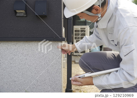 住宅の基礎部分をチェックする男性 129210969
