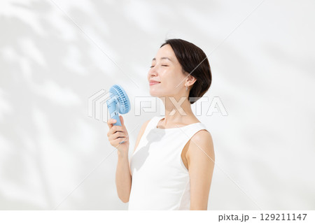 ハンディファンを使う女性 129211147