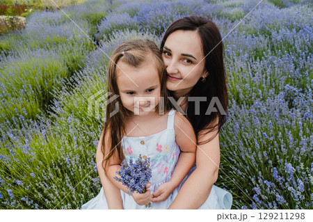 In a lavender field, a mother and daughter look like fairy tale characters 129211298