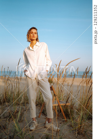 Stylish woman enjoying autumn weather outdoor. Fashion, style concept. People, lifestyle, relaxation Stylish woman enjoying autumn weather outdoor. Fashion, style concept. People, lifestyle, relaxation 129211352