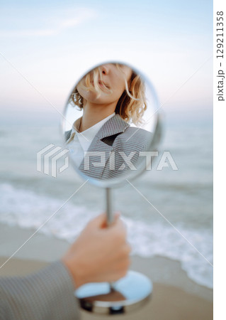 Fashion Model posing near the sea. Young woman resting in nature. People, lifestyle, relaxation. 129211358