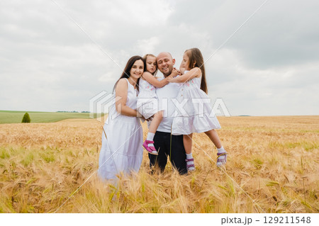 A friendly family has gathered in a golden field of barley A friendly family has gathered in a golden field of barley 129211548