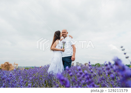 A lavender field in golden light. A brutal man gently embraces his beloved 129211579